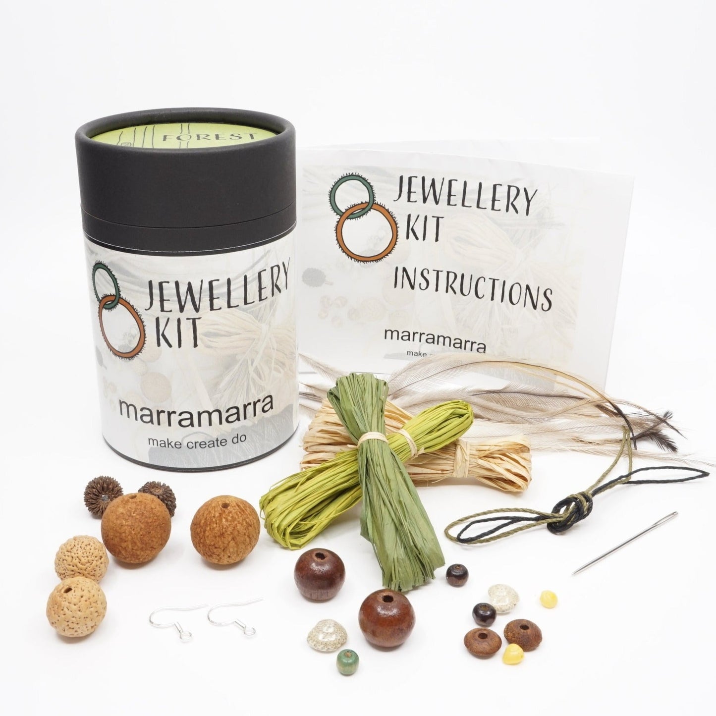 Forest green raffia, seeds, feathers and beads spread out of an Aboriginal jewellery kit